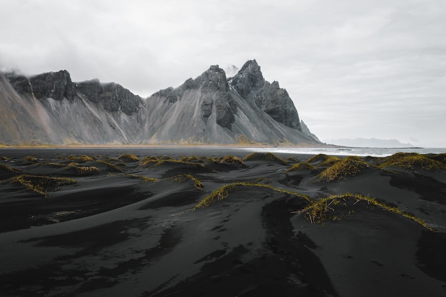 Mountain peaks above black sand dunes